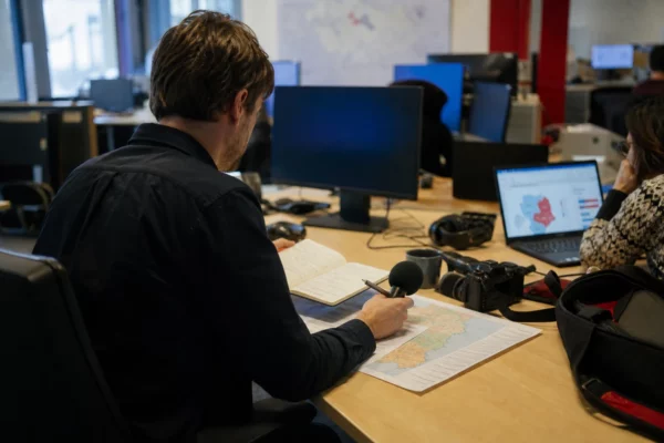 Journaliste préparant en rédaction une analyse électorale sur la percée de l’extrême droite en Allemagne