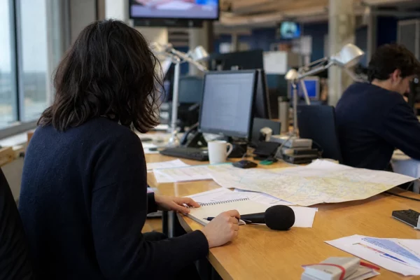 Journaliste préparant un sujet sur une primaire politique dans une rédaction locale française lumineuse