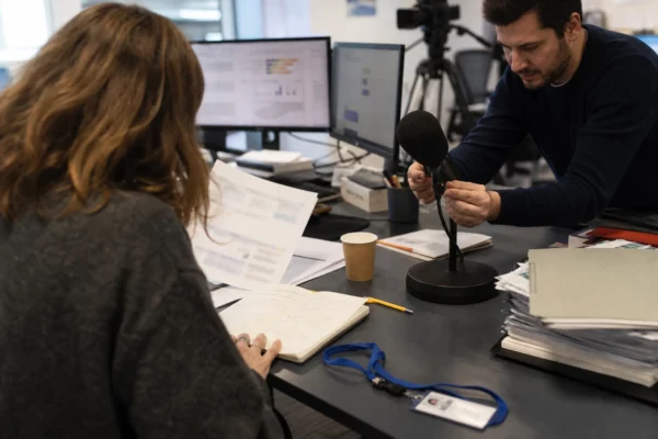 Journalistes anonymes préparant en rédaction un sujet sur les promesses présidentielles et les finances publiques
