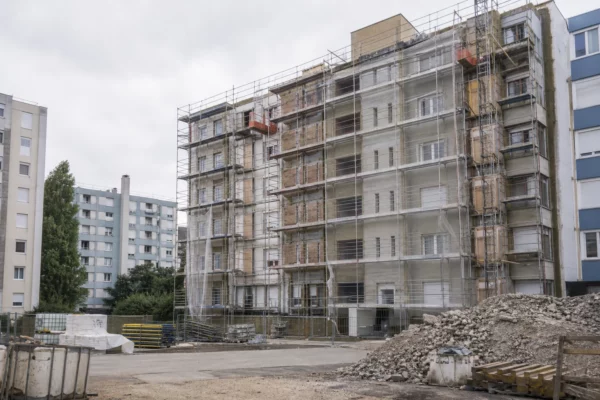 Des immeubles HLM en rénovation, avec échafaudages et matériel de chantier, illustrent l’enjeu du logement social.
