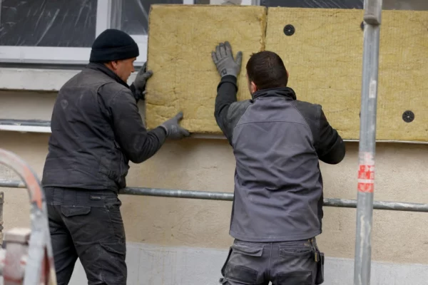 Chantier de rénovation thermique d’un immeuble, avec échafaudages et matériaux d’isolation en façade.