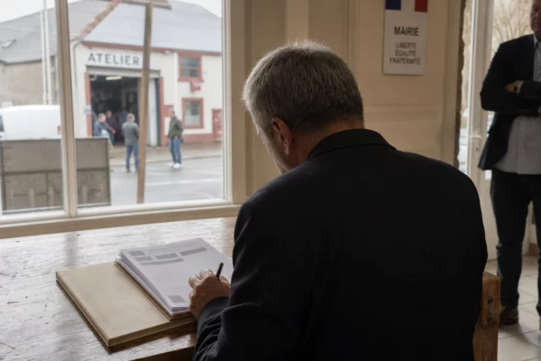 Élu local anonyme étudiant un dossier de reprise d’entreprise dans une mairie française lumineuse