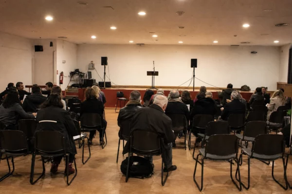 Salle de réunion politique à Alfortville avec chaises alignées, pupitre et matériel de sonorisation.