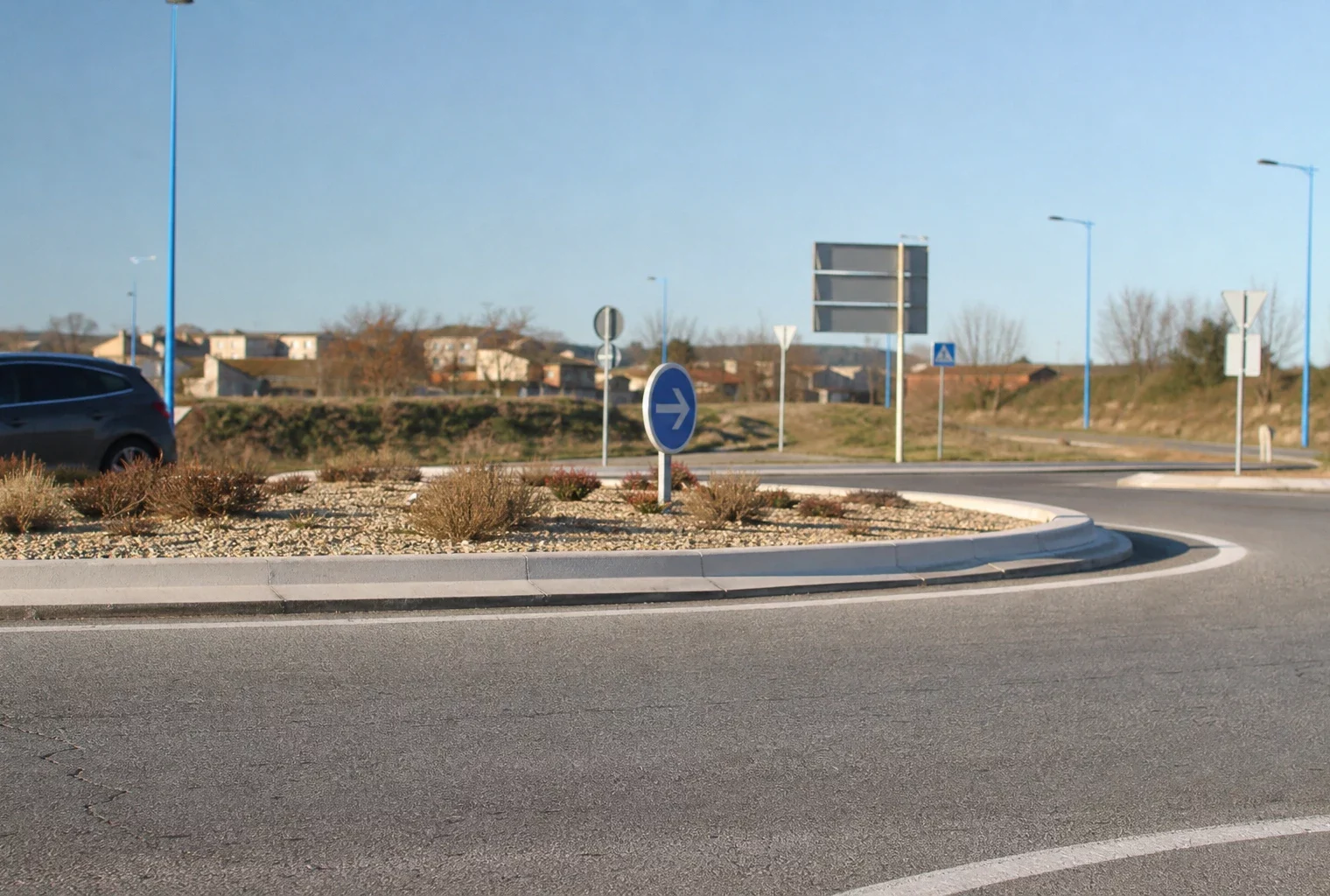 Un rond-point de périphérie avec ses voies d’accès et son terre-plein central, en France.