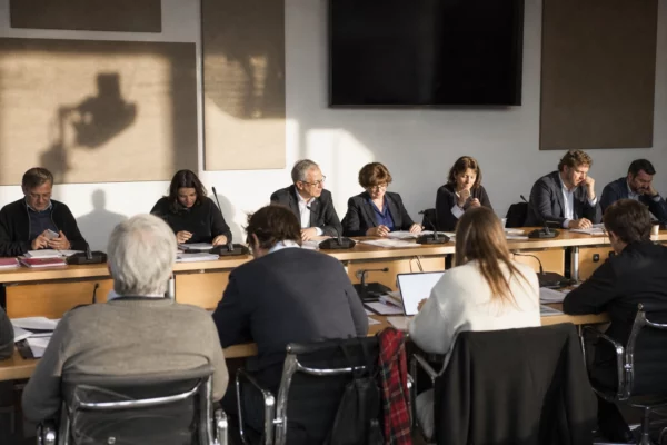 Salle de réunion sobre avec table, micros et chaises, évoquant une décision interne du Parti socialiste.