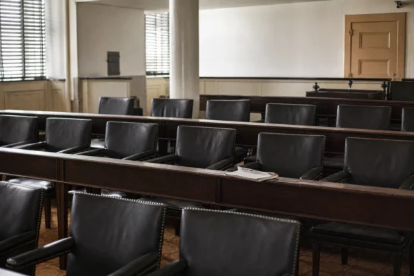Salle du conseil municipal vide dans une mairie du Doubs, tables en bois, chaises alignées et lumière douce neutre.