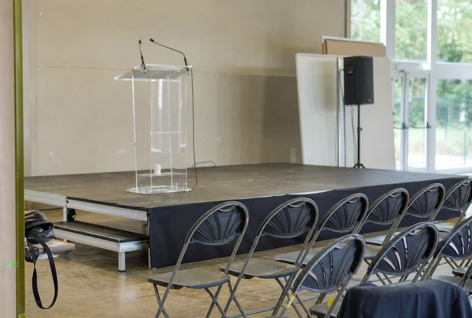 Salle de réunion politique avec estrade, pupitre et rangées de chaises, lors d’une rentrée militante à L’Isle-sur-la-Sorgue