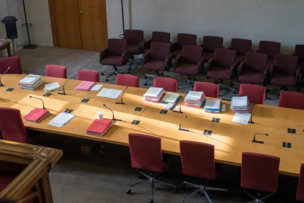 Salle de réunion à l’Assemblée nationale avec dossiers budgétaires et micros, avant une négociation entre députés socialistes et gouvernement.