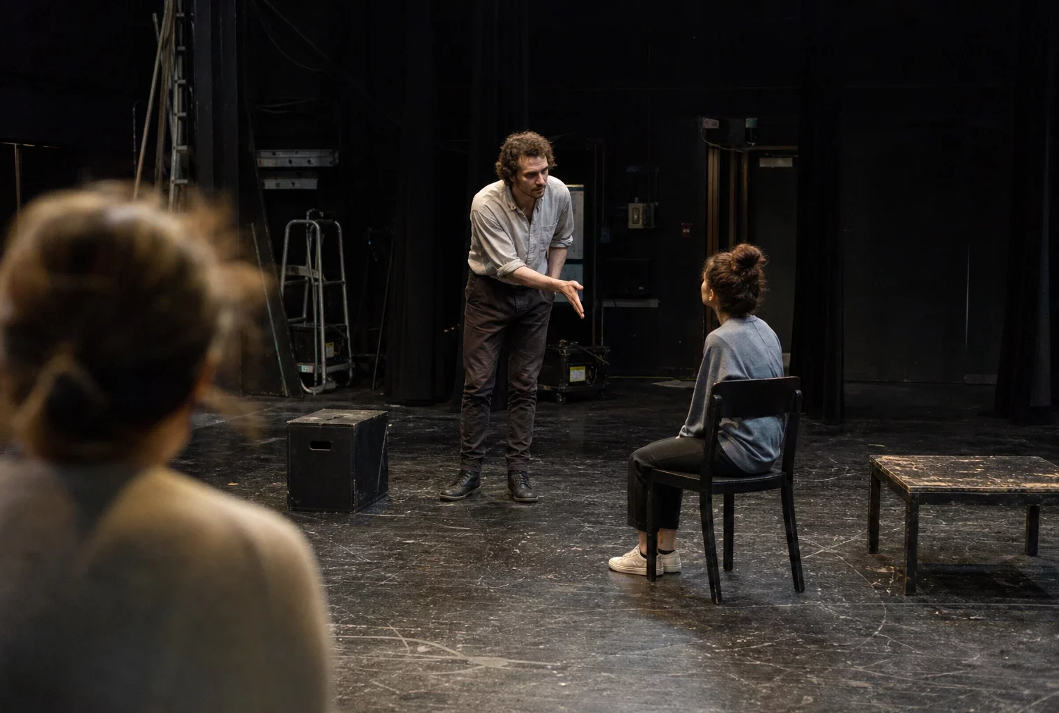Une scène de théâtre avec quelques chaises et accessoires, évoquant une pièce sur les présidents de la Ve République.