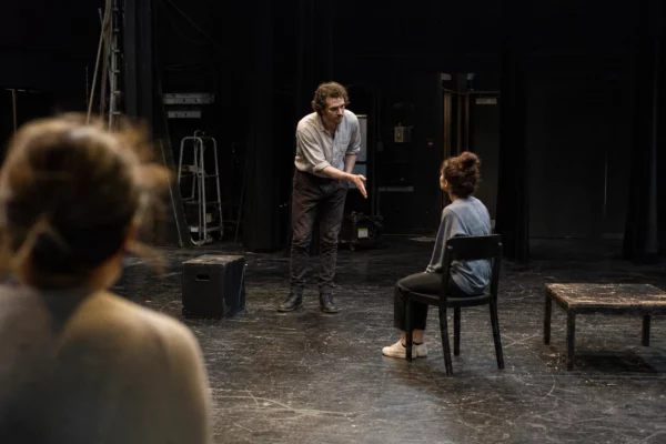 Une scène de théâtre avec quelques chaises et accessoires, évoquant une pièce sur les présidents de la Ve République.