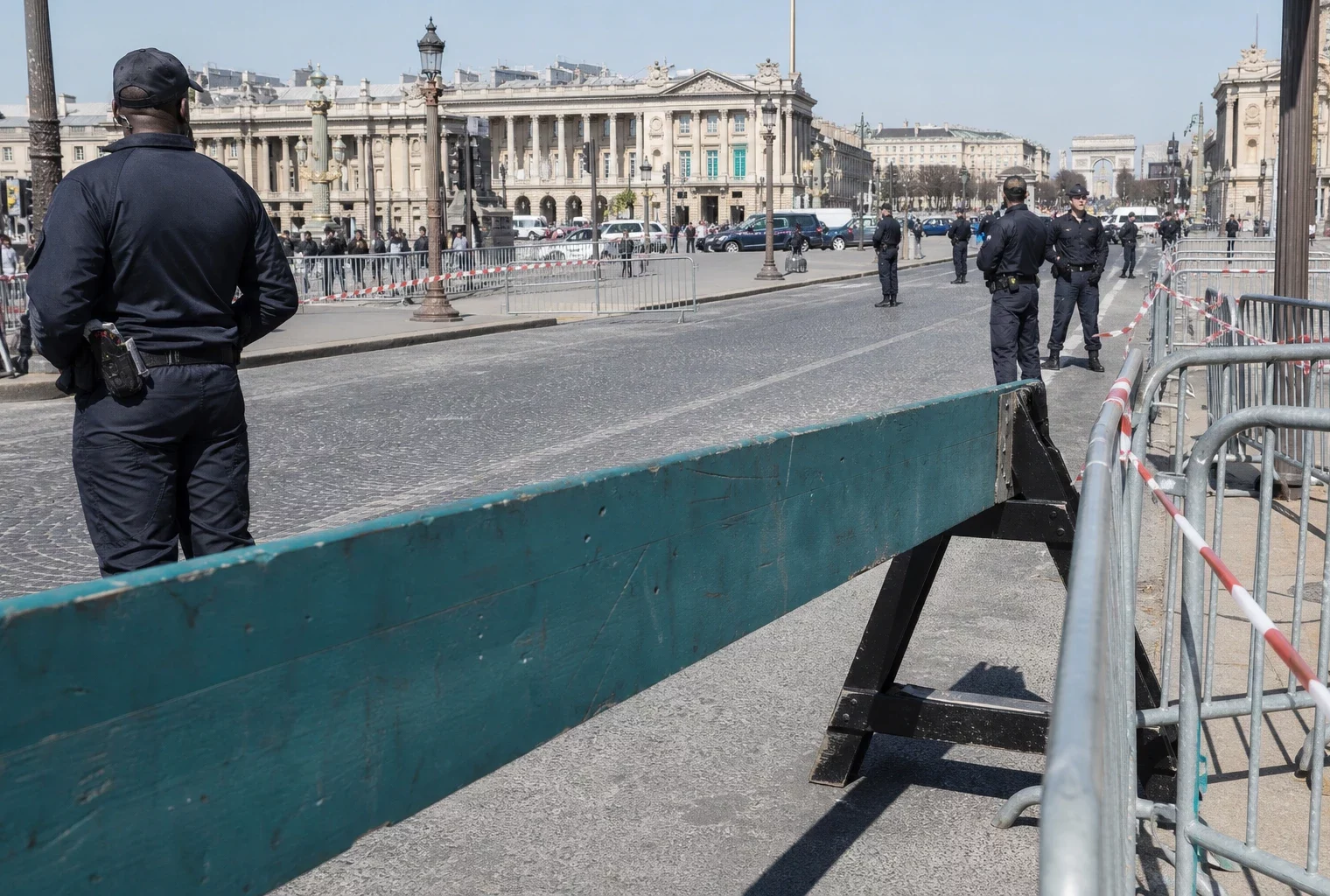 Barrières de sécurité et agents de contrôle sur l’axe Concorde-Champs-Élysées, sous le soleil du matin.