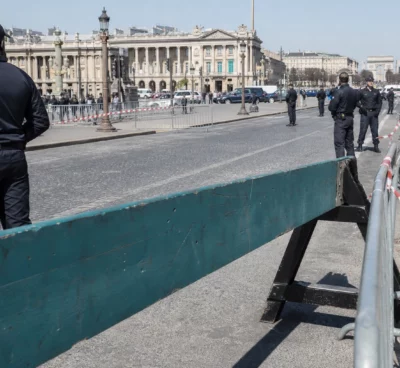 Barrières de sécurité et agents de contrôle sur l’axe Concorde-Champs-Élysées, sous le soleil du matin.