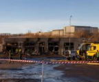 Façade d’entrepôt endommagée par un incendie, véhicules de secours stationnés et traces d’intervention sur un site industriel à Tallinn.