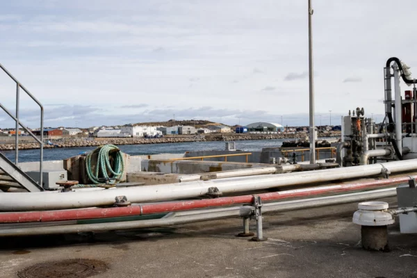Un terminal gazier au bord du port, avec tuyauteries et quais techniques dans un environnement maritime.