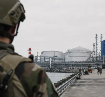 Terminal pétrolier de Yanbu avec cuves, tuyauteries et quais de chargement au bord de la mer sous un ciel gris.