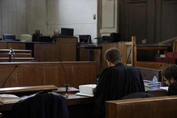 Salle d’audience du tribunal judiciaire de Paris avec tables d’avocats et dossiers pour une audience en référé.