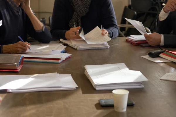 Dossiers de candidatures et feuilles de validation sur une table de réunion au siège du Parti socialiste