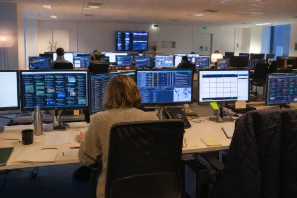 Salle de veille avec écrans de suivi des réseaux sociaux et postes techniques dans un ministère à Paris