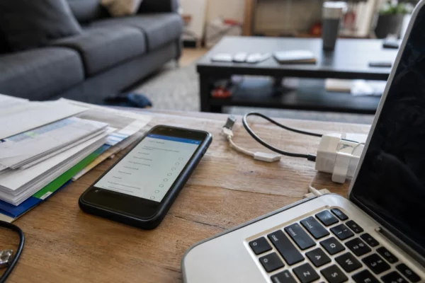 Un smartphone affiche un écran de vérification d’âge dans un salon familial, pour illustrer le contrôle des comptes adolescents.