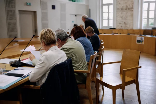 Salle de conseil local avec une chaise vide, des micros et des dossiers après un scrutin régional