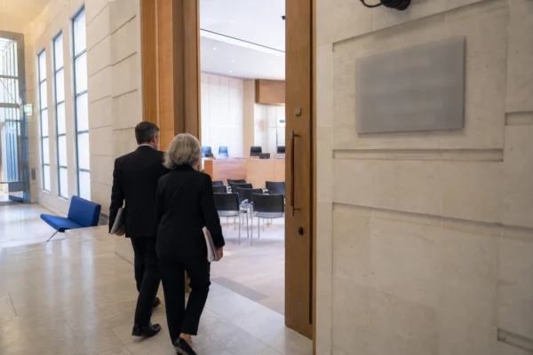 Couloir lumineux d’une institution publique française menant à une salle d’audition sur les libertés publiques