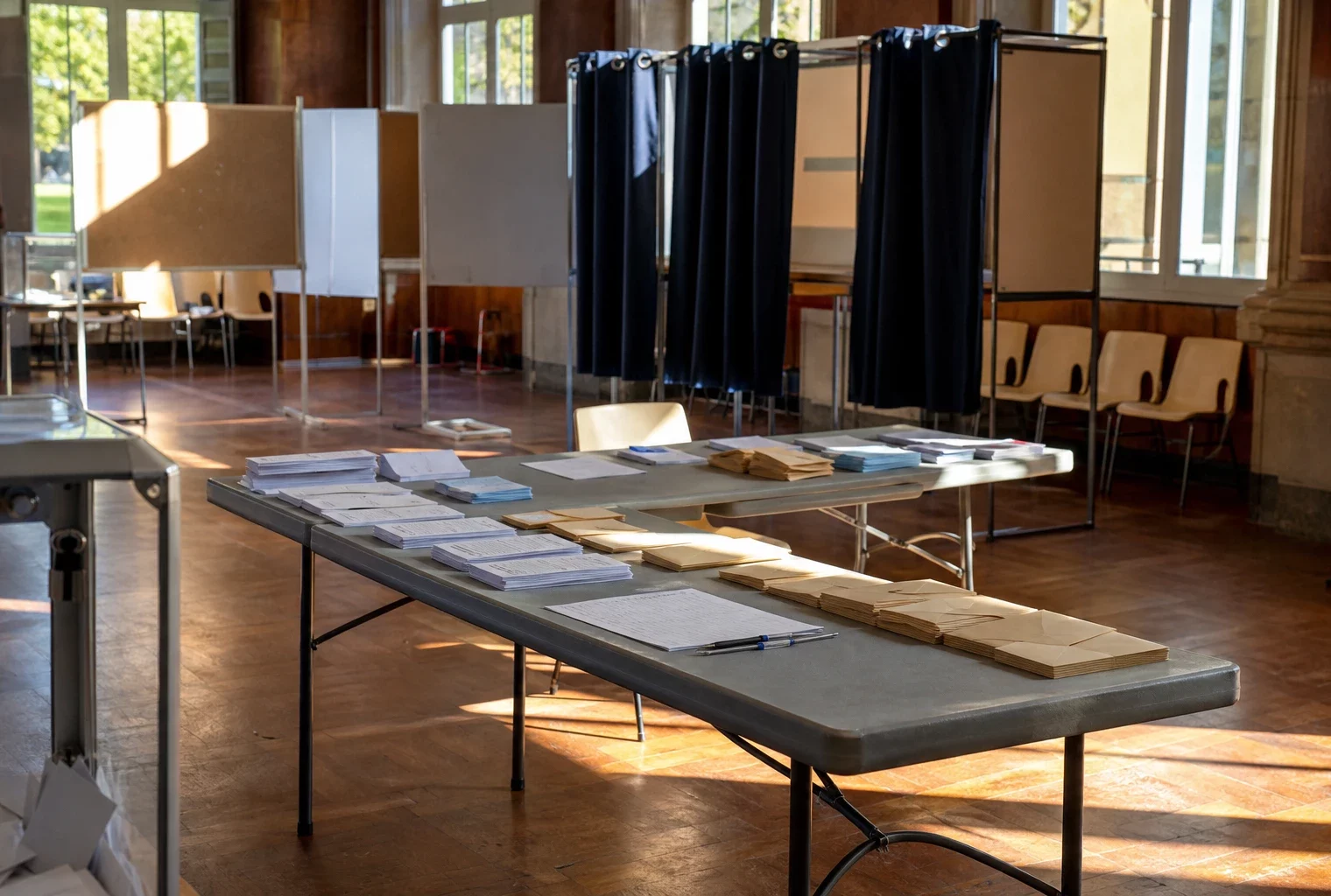 Salle de vote des grands électeurs avec tables, bulletins et isoloirs pour l’élection sénatoriale dans le Rhône.