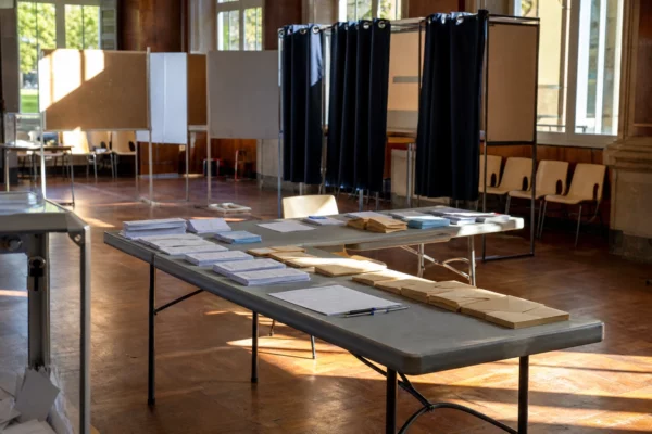 Salle de vote des grands électeurs avec tables, bulletins et isoloirs pour l’élection sénatoriale dans le Rhône.