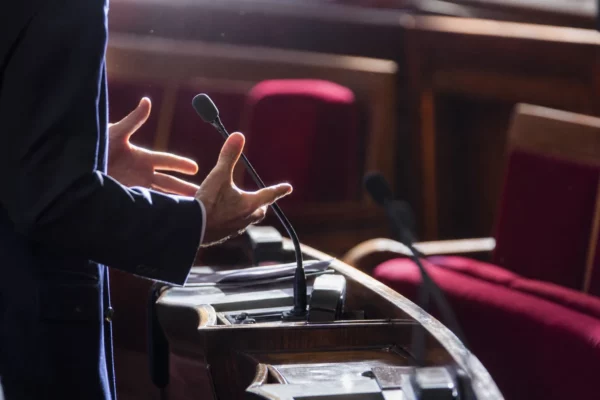 L’hémicycle de l’Assemblée nationale vide, avec ses pupitres et ses micros en rangées.