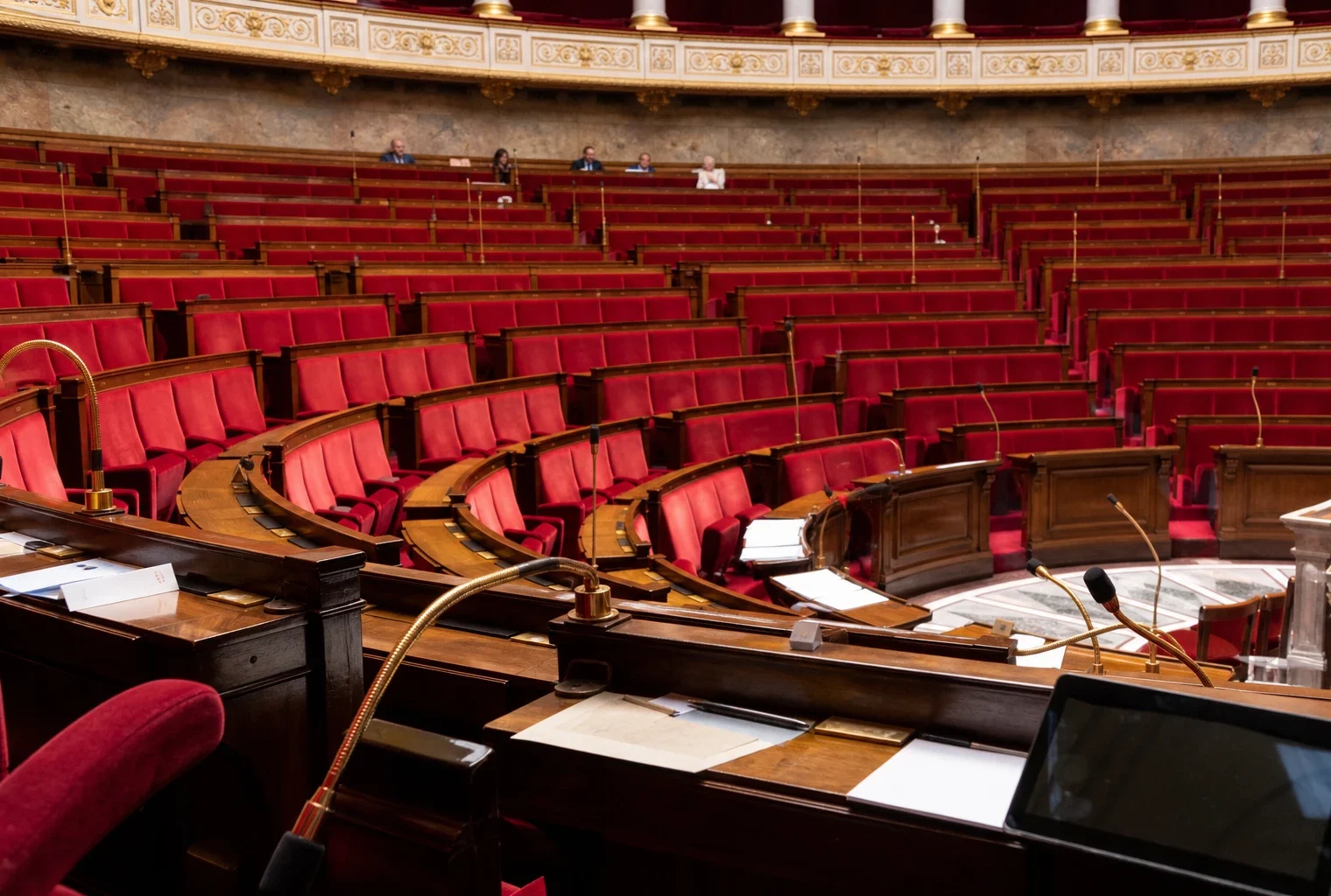 L’hémicycle de l’Assemblée nationale avec ses pupitres et micros, cadre institutionnel lié au débat politique.