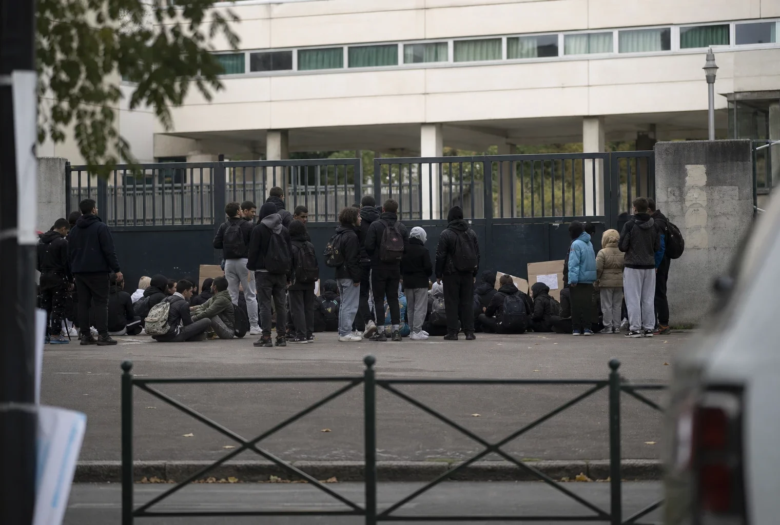 Des élèves se rassemblent devant les grilles fermées d’un lycée, au début d’une mobilisation pour les moyens.
