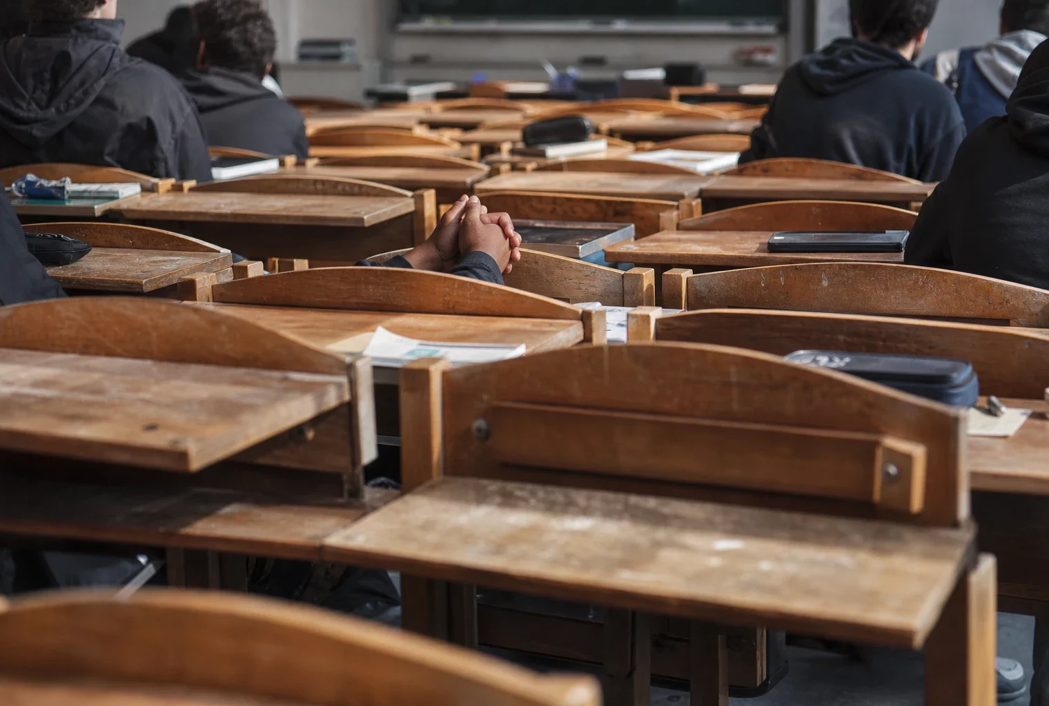 Salle de classe trop petite dans un lycée de Seine-Saint-Denis, rangées de chaises et tables serrées, quelques places vides.