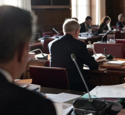 Salle de commission à l’Assemblée nationale avec pupitres, micros et dossiers avant l’examen du budget