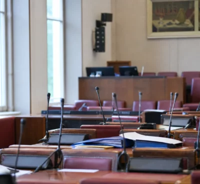 La salle de la commission des Finances à l’Assemblée nationale, avec pupitres, micros et dossiers de séance