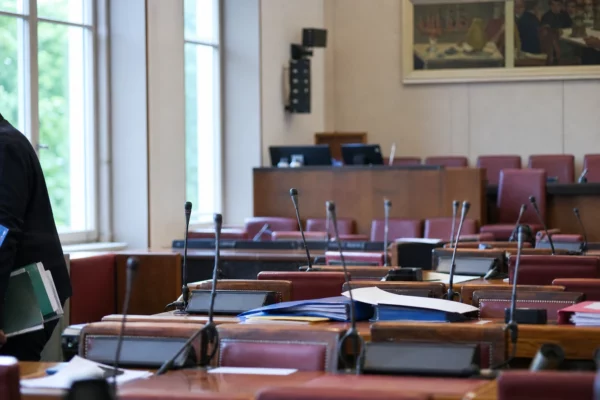 La salle de la commission des Finances à l’Assemblée nationale, avec pupitres, micros et dossiers de séance