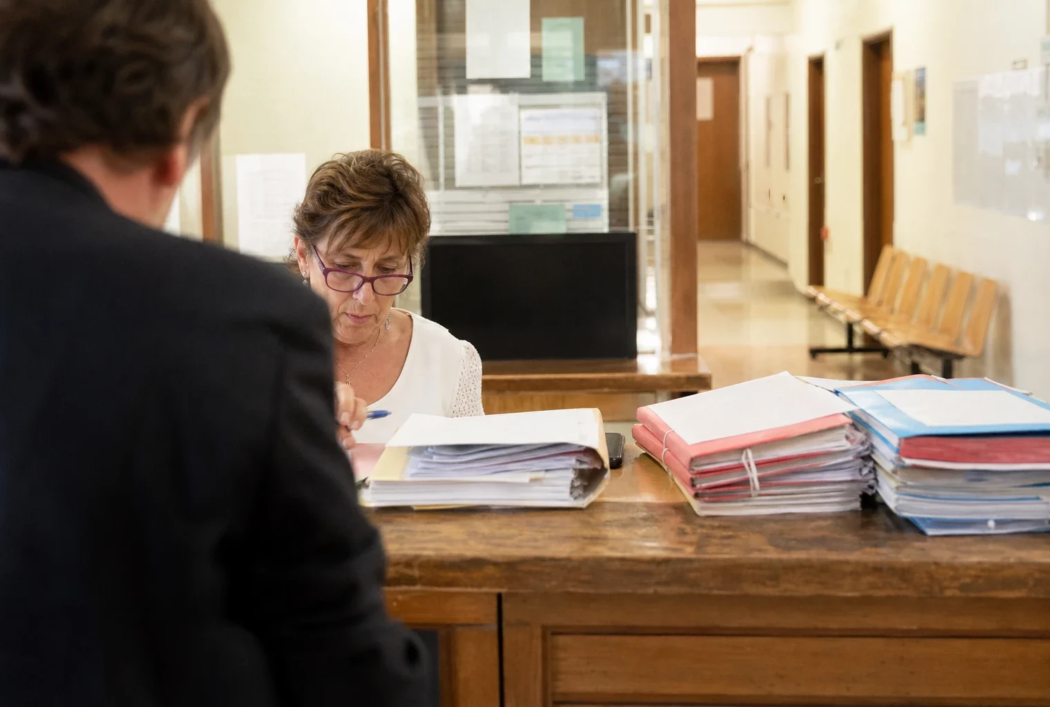 Guichet du greffe d’un tribunal où un dossier de plainte en diffamation est déposé.