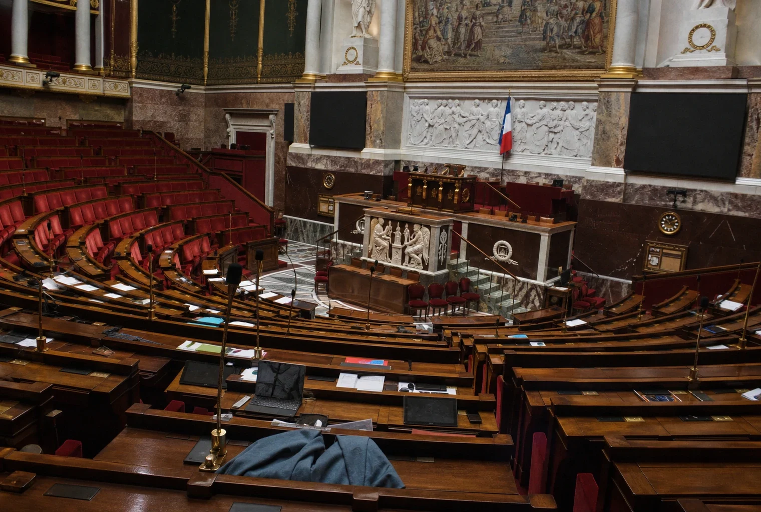 L’hémicycle de l’Assemblée nationale, avec ses rangées de sièges et ses pupitres, où se joue le budget 2027.