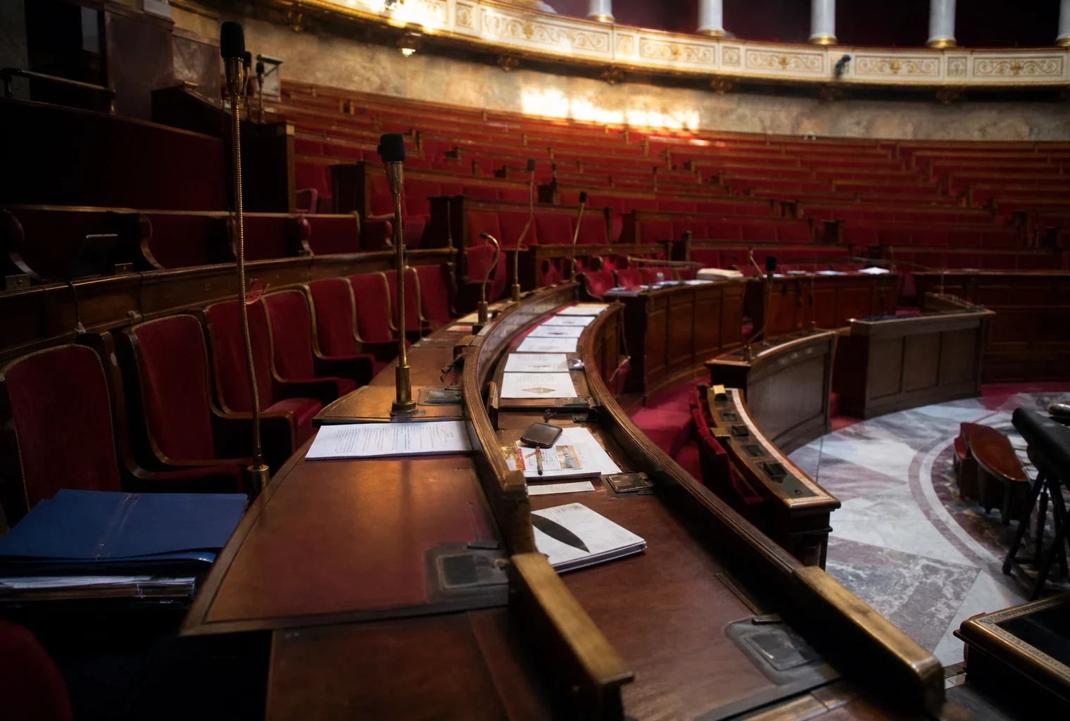 L’hémicycle de l’Assemblée nationale avec ses pupitres et micros, où se discute la proposition de loi.