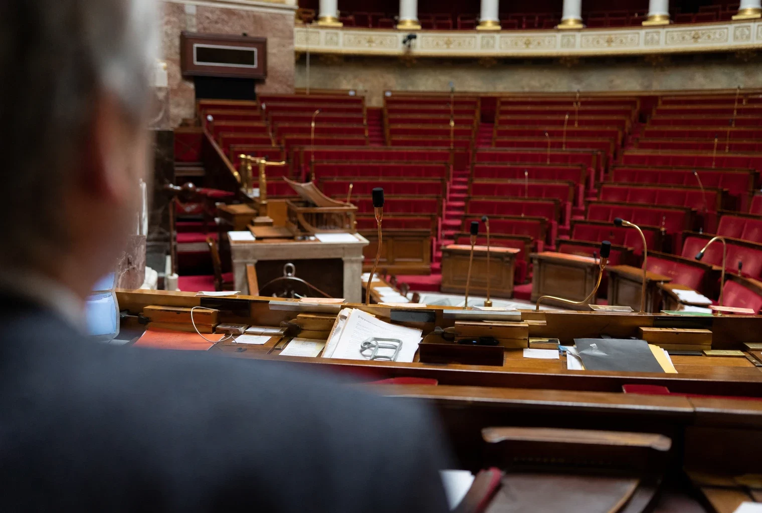 L’hémicycle de l’Assemblée nationale avec ses pupitres et micros, où se jouent les débats budgétaires.