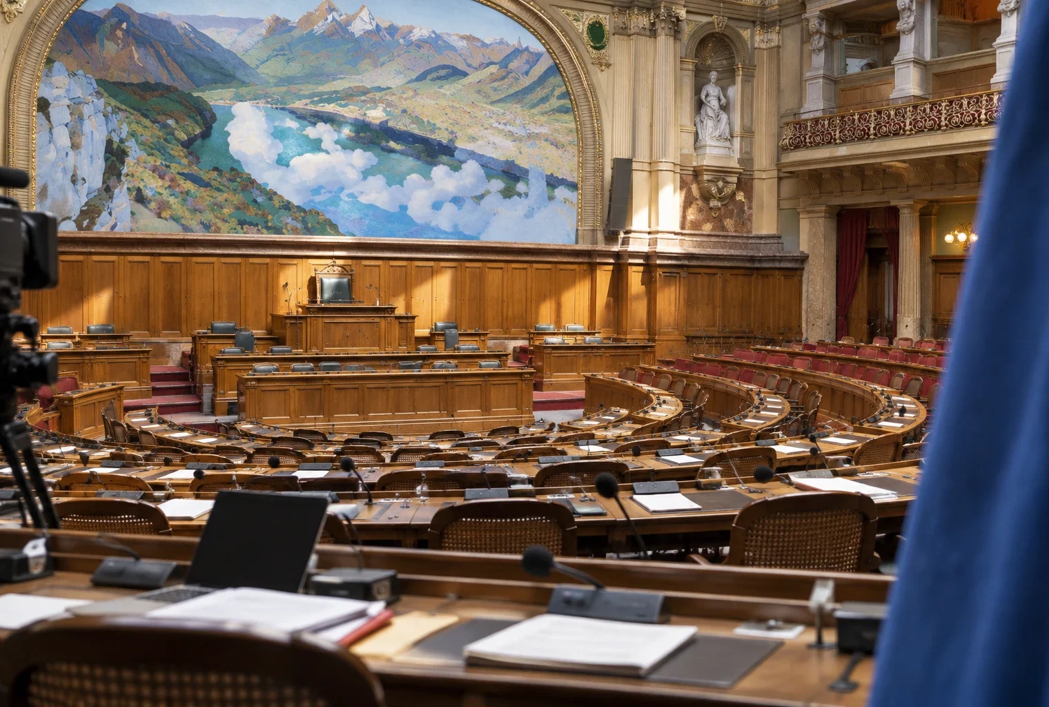 Dans l’hémicycle, des pupitres équipés de microphones et des sièges s’étagent devant les gradins et la tribune.