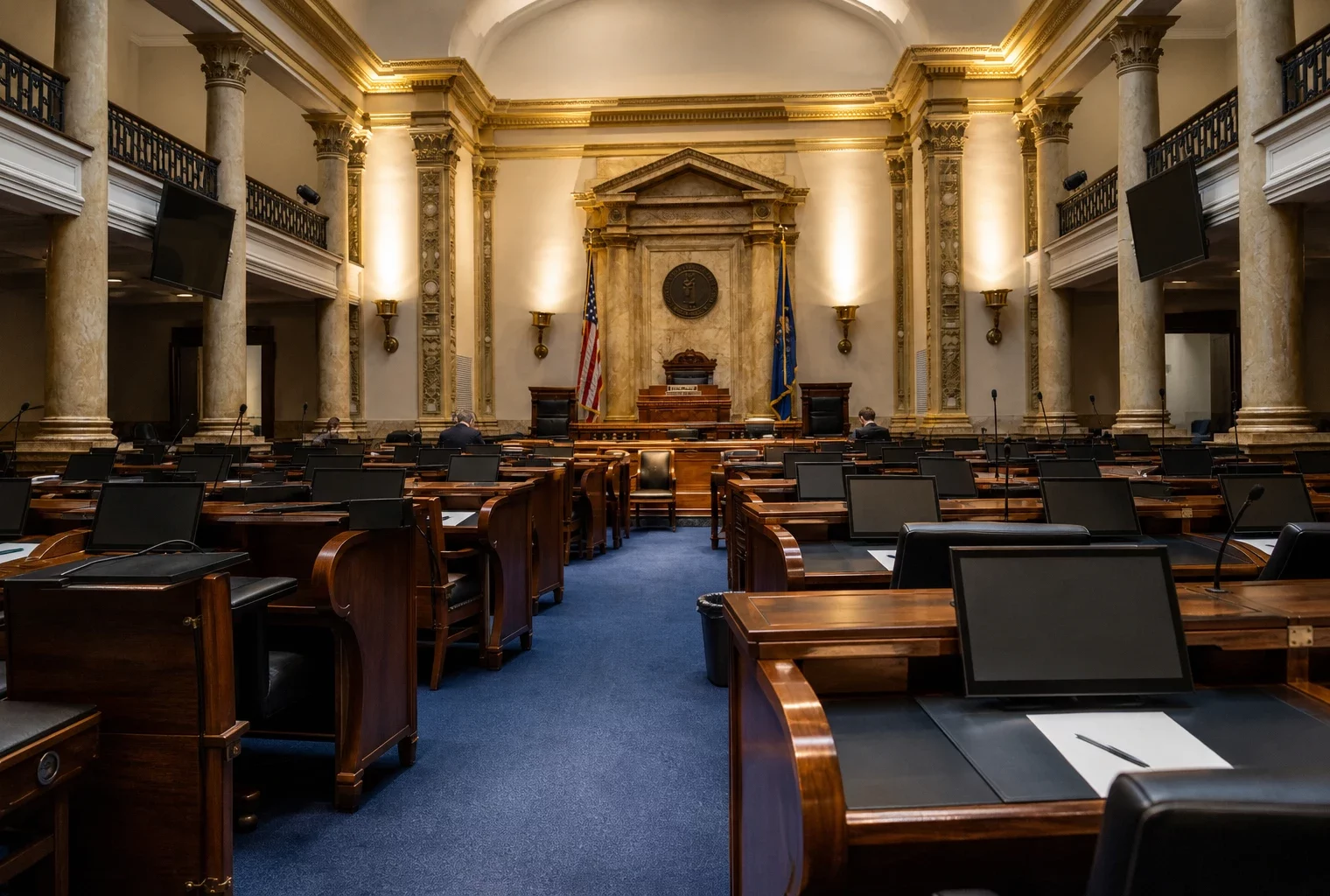 L’hémicycle du Sénat vide, avec les pupitres au premier plan et le fauteuil de présidence au centre.