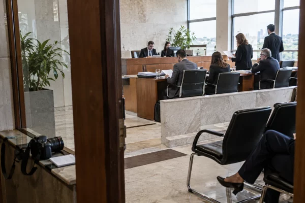 Des observateurs anonymes échangent dans une salle d’audition lumineuse d’un bâtiment de justice électorale au Brésil.