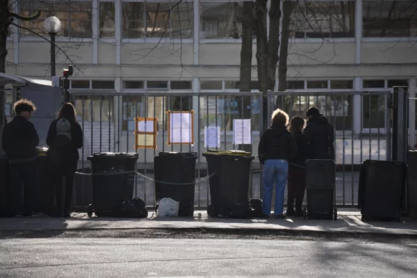 Entrée de lycée bloquée par des barrières et des objets posés devant le portail.