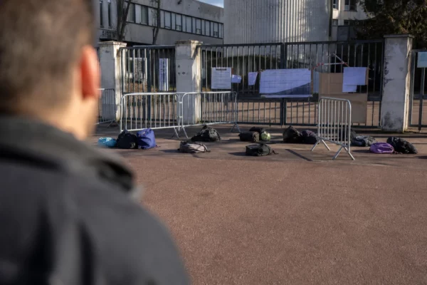 Entrée d’un lycée bloqué avec grilles fermées et barrières devant l’établissement