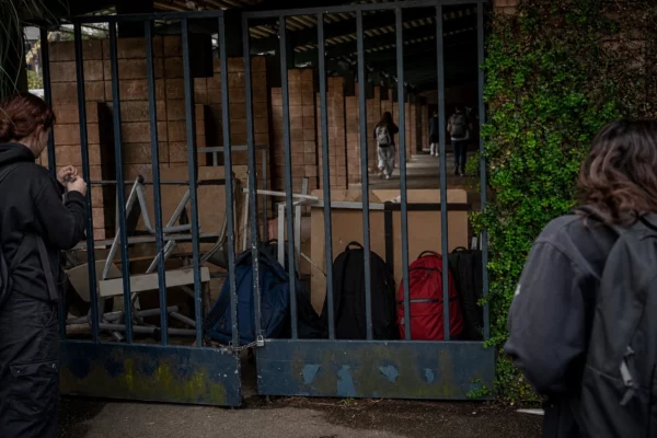 Grilles fermées d’un lycée en France, sacs d’élèves et barrage improvisé devant l’entrée, ambiance tendue.