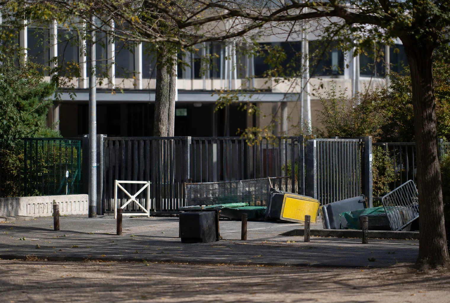 Entrée d’un lycée bloquée par des barrières et du mobilier déplacé lors d’une mobilisation étudiante.