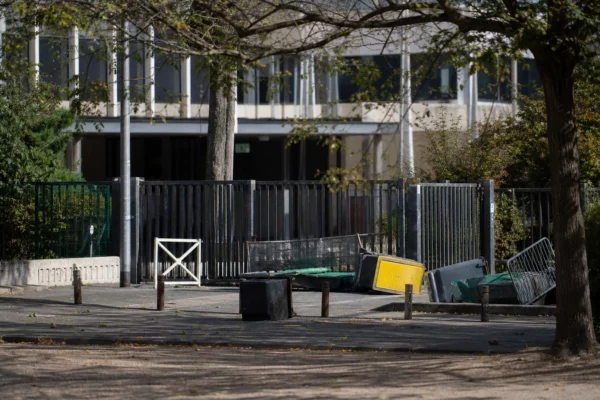 Entrée d’un lycée bloquée par des barrières et du mobilier déplacé lors d’une mobilisation étudiante.
