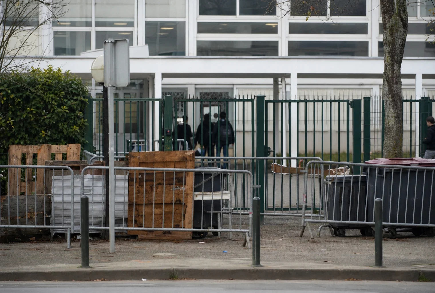 Devant un lycée bloqué, des barrières ferment l’entrée après des affrontements et des dégradations.