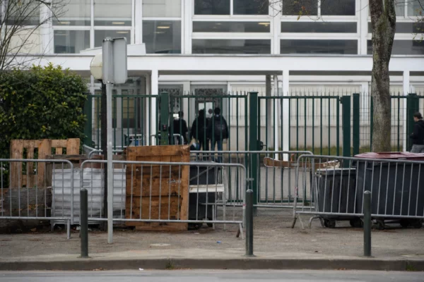 Devant un lycée bloqué, des barrières ferment l’entrée après des affrontements et des dégradations.