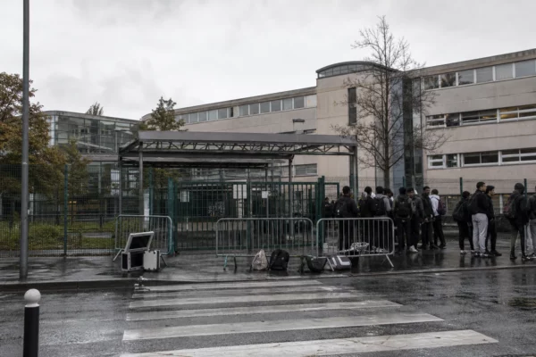 Devant le lycée Paul-Éluard à Saint-Denis, l’entrée bloquée avec des élèves rassemblés sur le trottoir.
