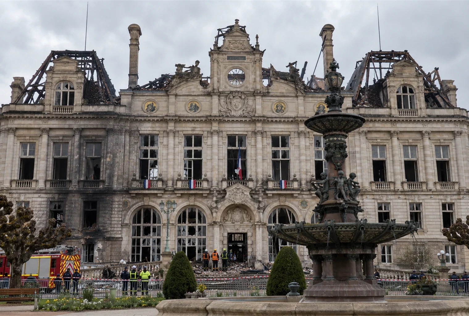 Vue de l’hôtel de ville de Limoges au lendemain de l’incendie, avec sa toiture détruite, sa charpente calcinée et des pompiers devant le bâtiment